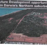 Aerial photograph from a newspaper clipping showing coastal bushland at Lee Point, Darwin, marked as Lot 12743, with red dirt land clearing and initial street grids in the foreground.